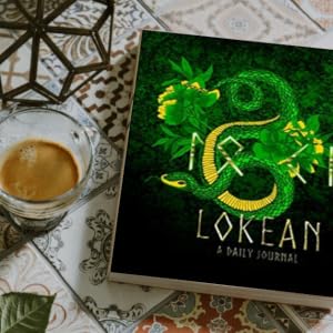 A daily journal titled 'LOKEAN' featuring a green dragon illustration, styled on a patterned tablecloth next to a glass of espresso.